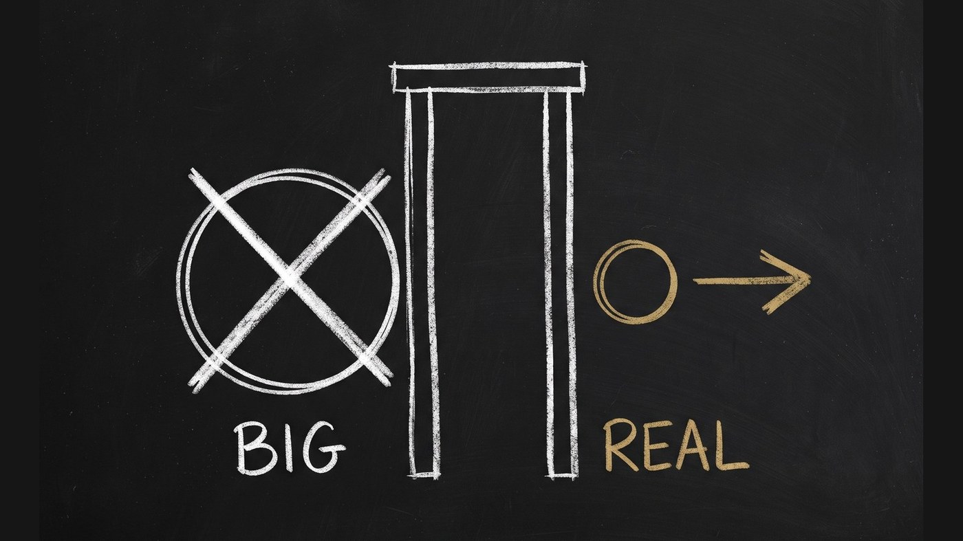 Chalkboard diagram: a large white chalk circle struck through with an X beside the word BIG, stopped at a chalk gate, while a small gold circle labelled REAL passes through the gate and continues right on an arrow.