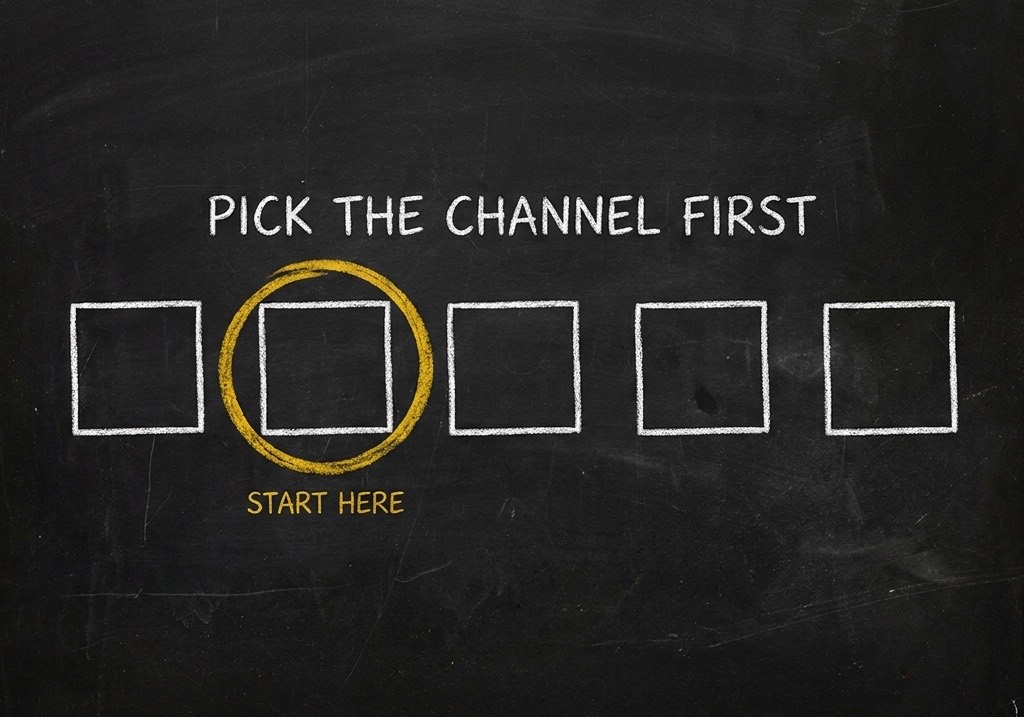 A chalkboard drawing of five plain squares in a row, the second circled in gold, under the heading PICK THE CHANNEL FIRST with START HERE marked beneath the circled square